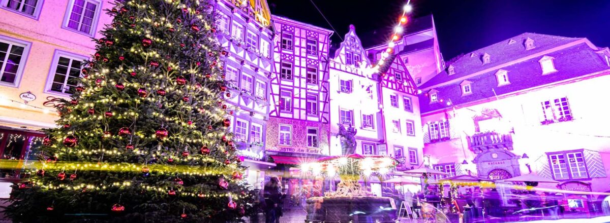 bunt beleuchtete Haeuser mit Weihnachtsbaum in Cochemer Altstadt