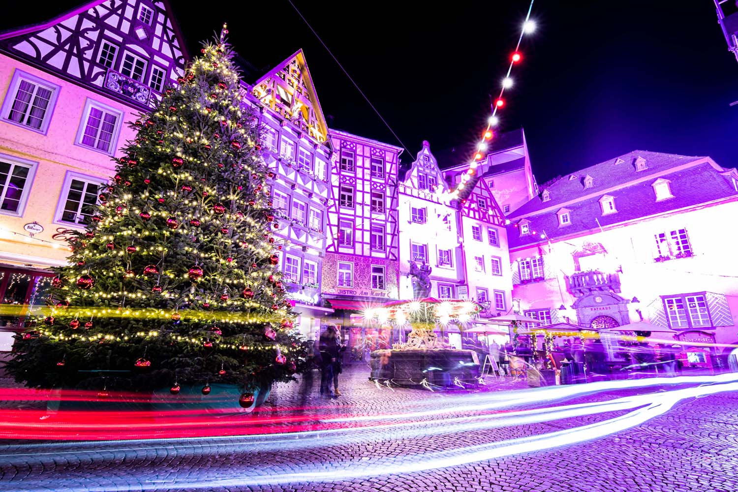 bunt beleuchtete Haeuser mit Weihnachtsbaum in Cochemer Altstadt